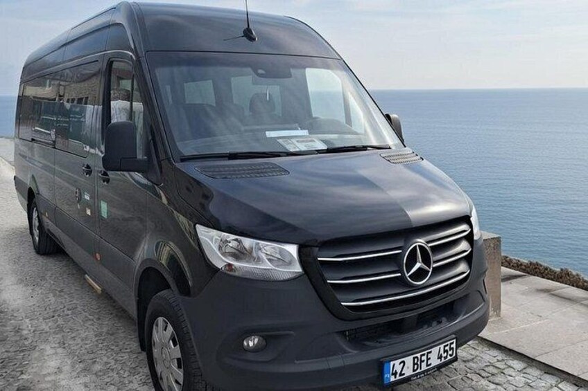 A black Mercedes-Benz van parked by the seaside. 2