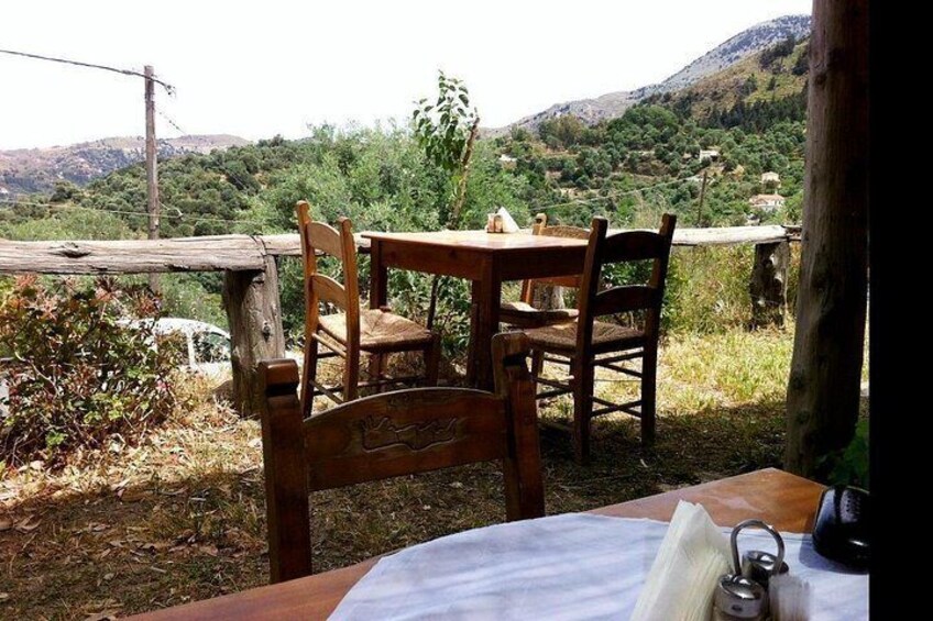 Un set di tavolo e sedie in legno all'aperto, con vista su un paesaggio collinare. 2