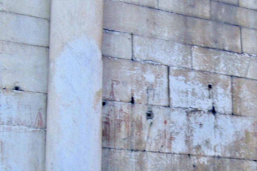 Un muro de piedra desgastado por la erosión, con varios agujeros. 1