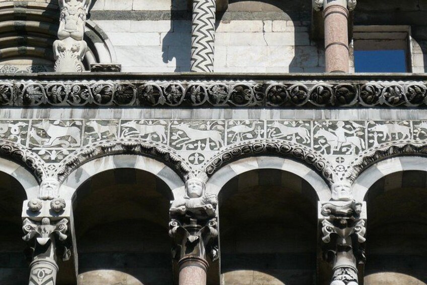 Ornate stone carvings and arches on a building facade. 1