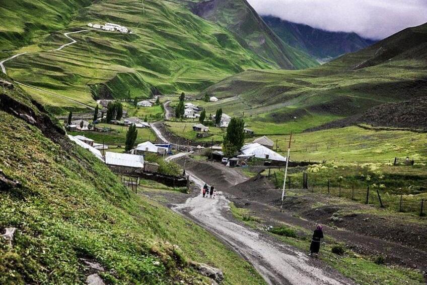 Un village rural niché dans une vallée, avec des maisons et une route sinueuse. 2