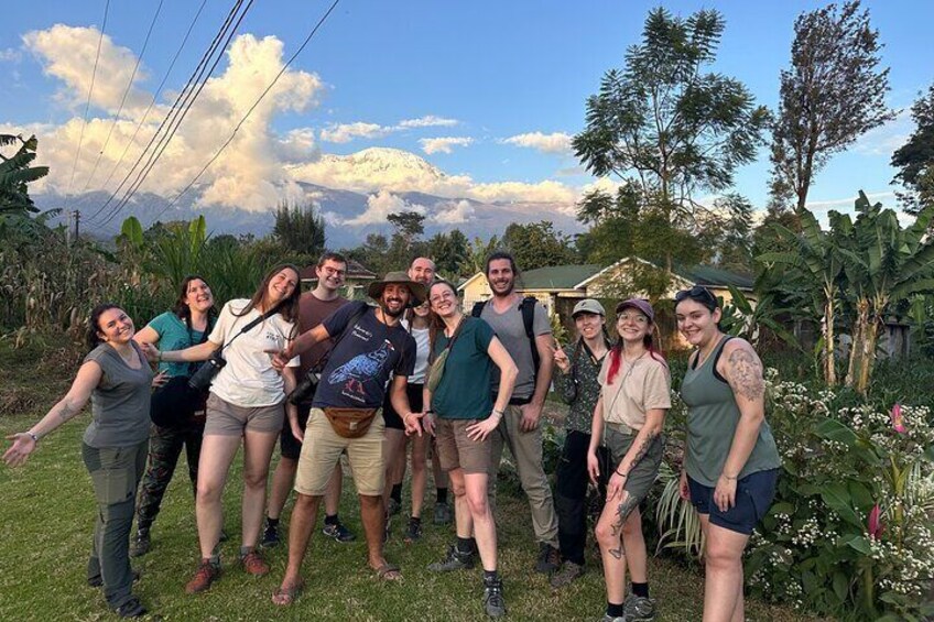 A group of people standing outdoors with a mountainous background. 5