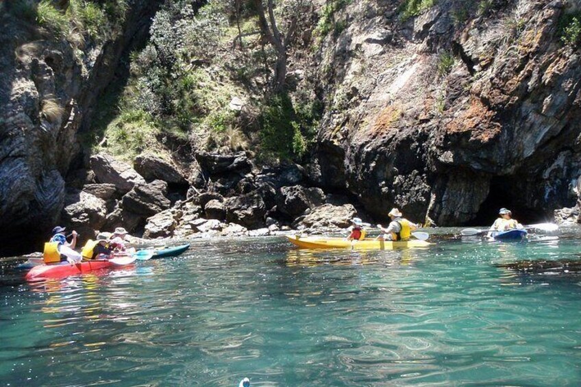 People kayaking on a river surrounded by rocky cliffs. 3