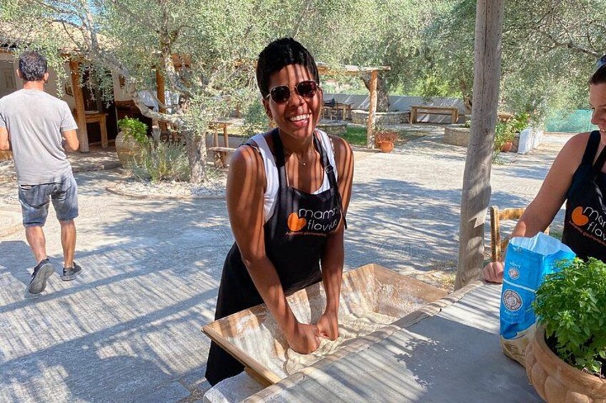 A person in a black tank top with a logo, holding a wooden board, and a bag of green plants. 5