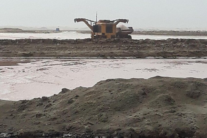 Un chantier de construction avec une grande excavatrice et un terrain boueux. 3