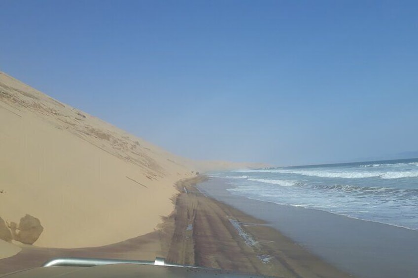 A sandy beach with waves crashing onto the shore. 5