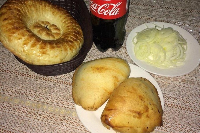 En korg med bröd, en flaska Coca-Cola och en tallrik med skivad lök. 2