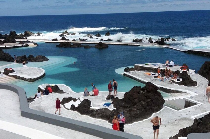 A coastal swimming area with rocky formations and clear blue water. 1