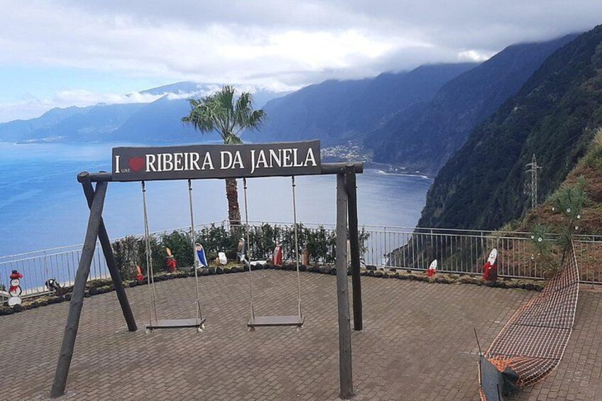 Un columpio con un cartel que dice 'I love Ribeira da Janela' con vistas a un paisaje costero. 4