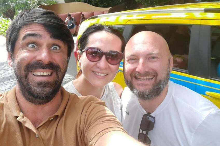 Three people taking a selfie with a yellow bus in the background. 2