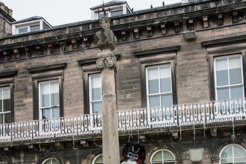 Un edificio histórico con balcones ornamentados y una columna de piedra. 2