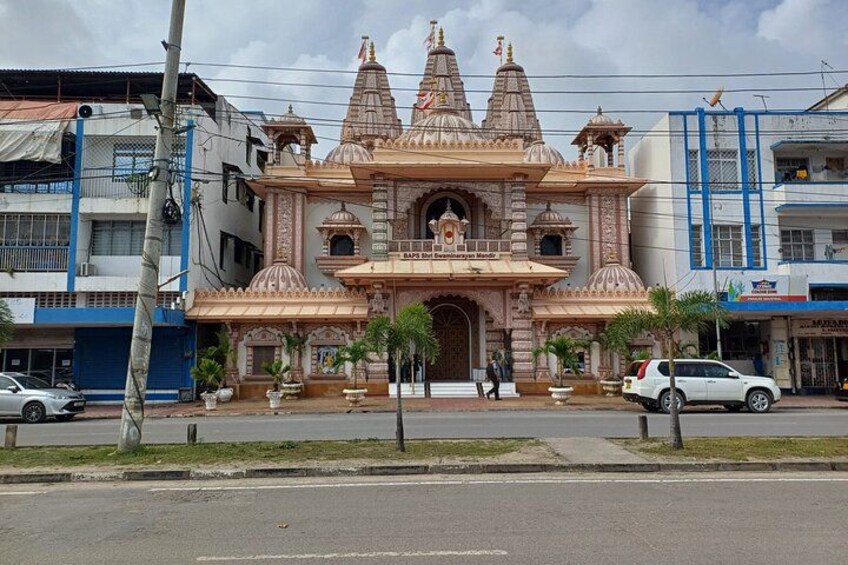 Un temple doté de plusieurs flèches et d’un sanctuaire central, entouré de palmiers et d’immeubles modernes. 3