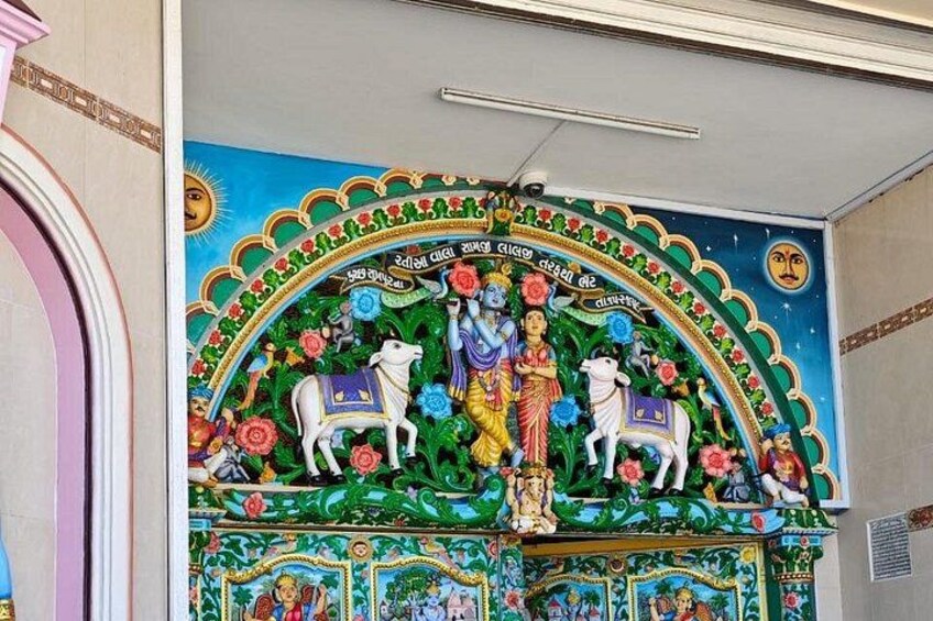Een kleurrijke muurschildering met godheden, bloemen en een centrale figuur. 3