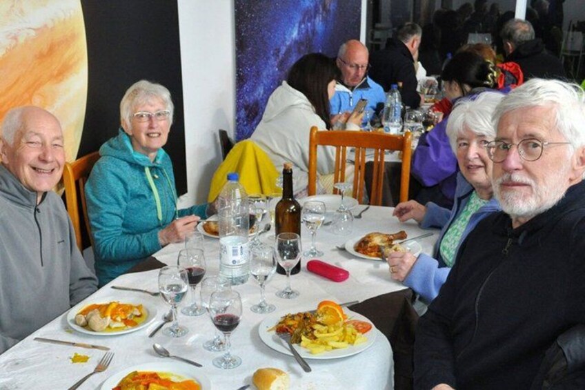 Un grupo de personas cenando en un restaurante, con varios platos y bebidas sobre la mesa. 2