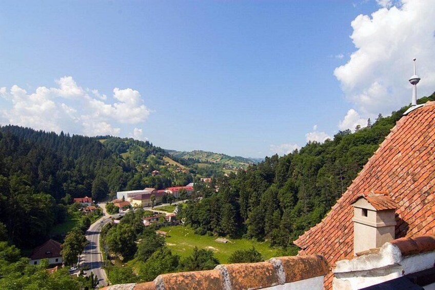 Un paysage montagneux avec un village, des champs en terrasses et une tour imposante. 3