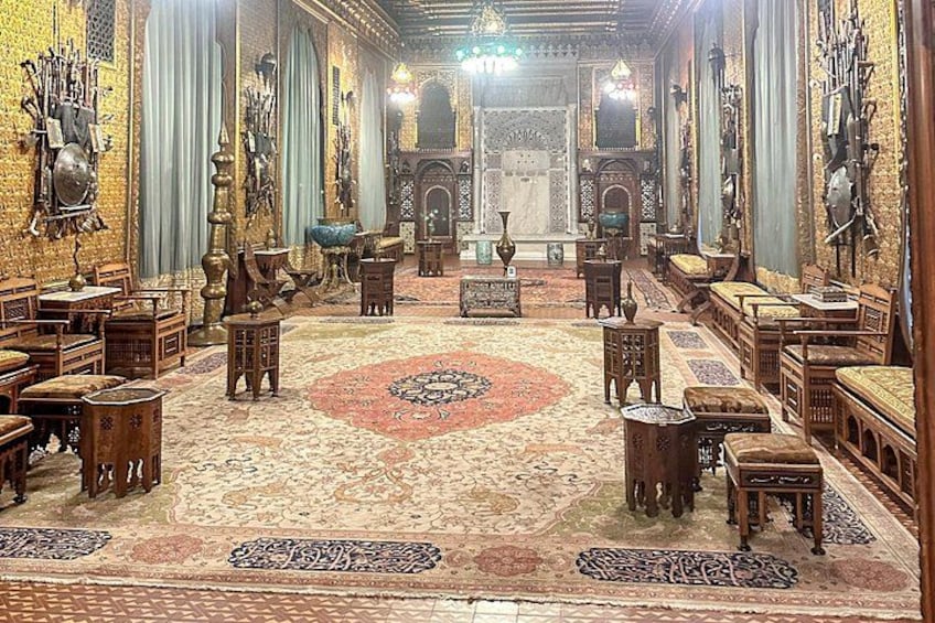 An ornate room with intricate woodwork, a patterned carpet, and traditional furnishings. 2