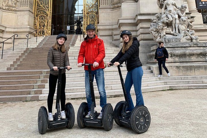 Three people on segways in front of a grand building with steps and a statue. 2