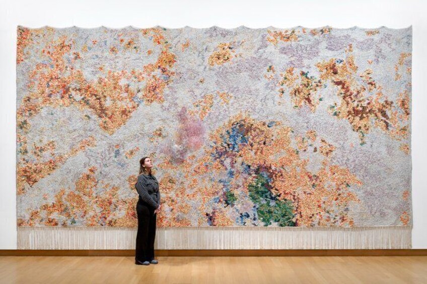 Une personne se tient devant un grand tableau abstrait. 5