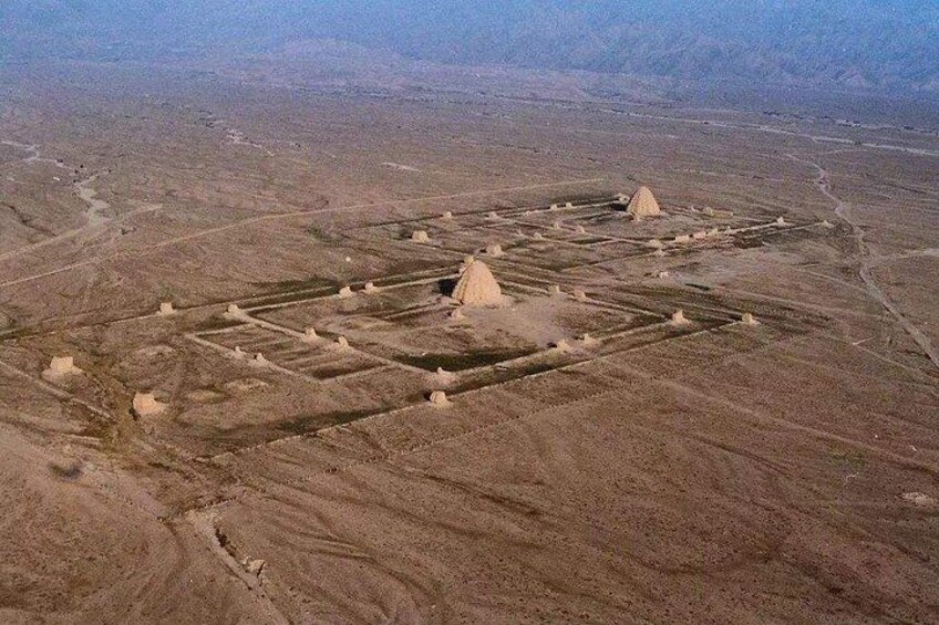 An aerial view of a desert landscape with ancient pyramid structures. 5