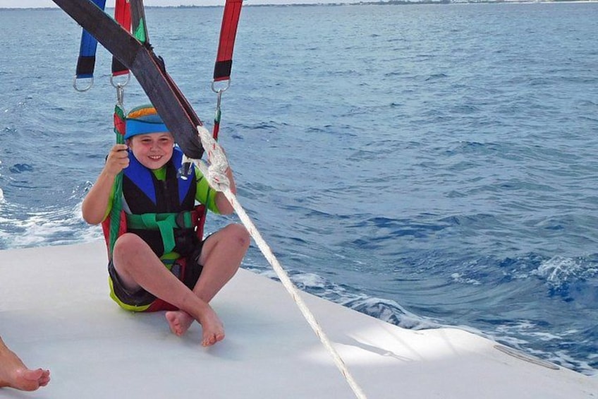 Een persoon op een zeilboot, die een reddingsvest draagt en zich vastklampt aan een touw. 5