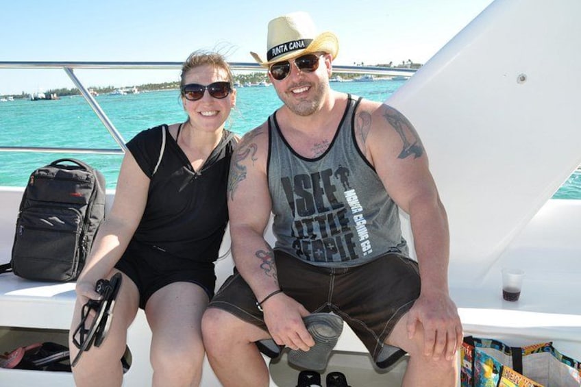 Two people on a boat with a clear blue sea and distant land in the background. 2