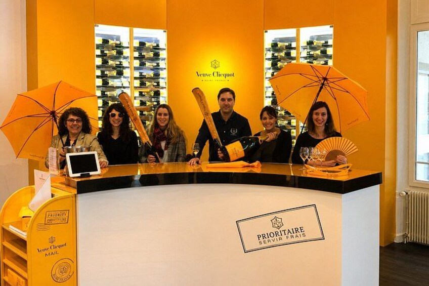 Un gruppo di persone dietro un bancone con il logo 'Vigne & Tequot'. 1