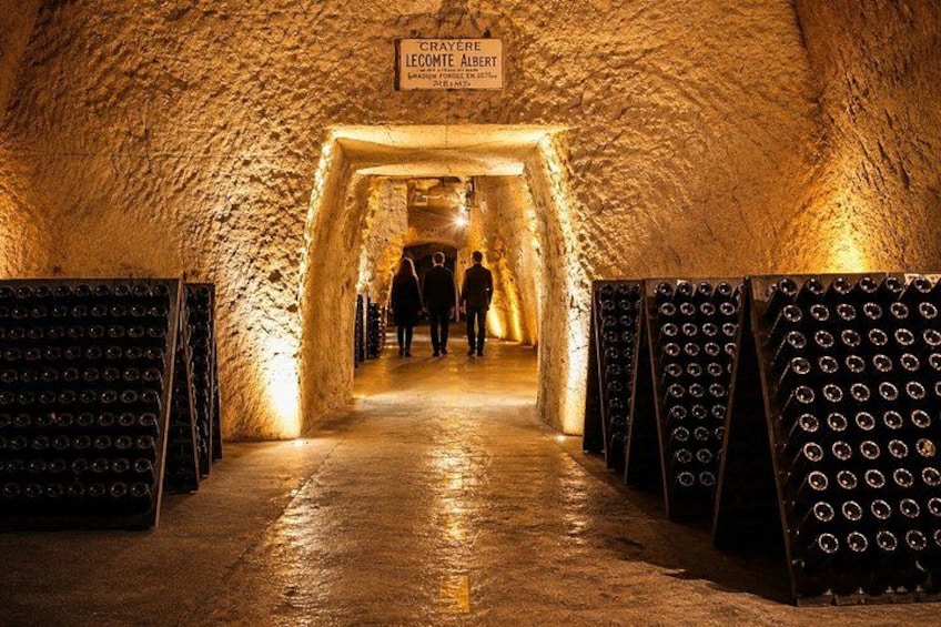 Un tunnel con un cartello che recita 'CRAYERE LECOMTE ALBERT' e persone che camminano verso la fine. 5