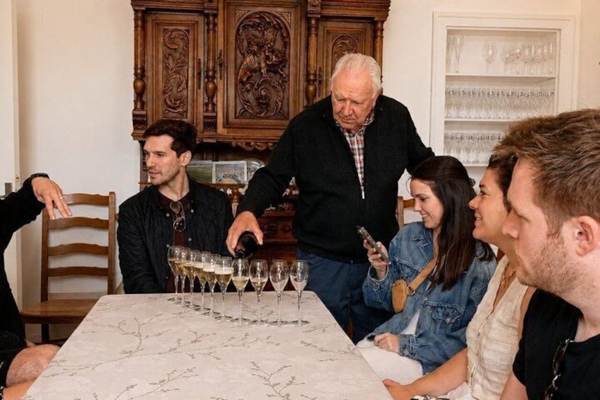 A group of people around a table with wine glasses. 3