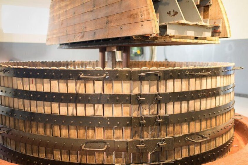 A large wooden barrel with metal bands and a metal structure on top. 5