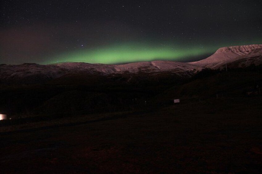 A night sky with the Northern Lights over a mountainous landscape. 3