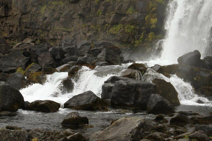 Ein Wasserfall stürzt über Felsen in felsigem Gelände. 2