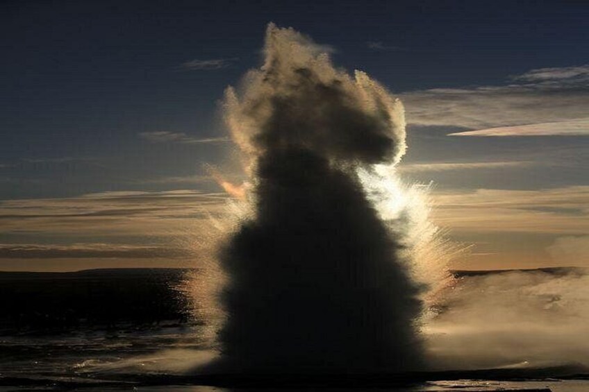 Un chorro de agua grande con la luz del sol reflejada. 2
