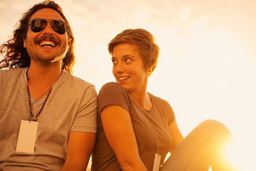 Two people sitting outdoors during sunset. 3