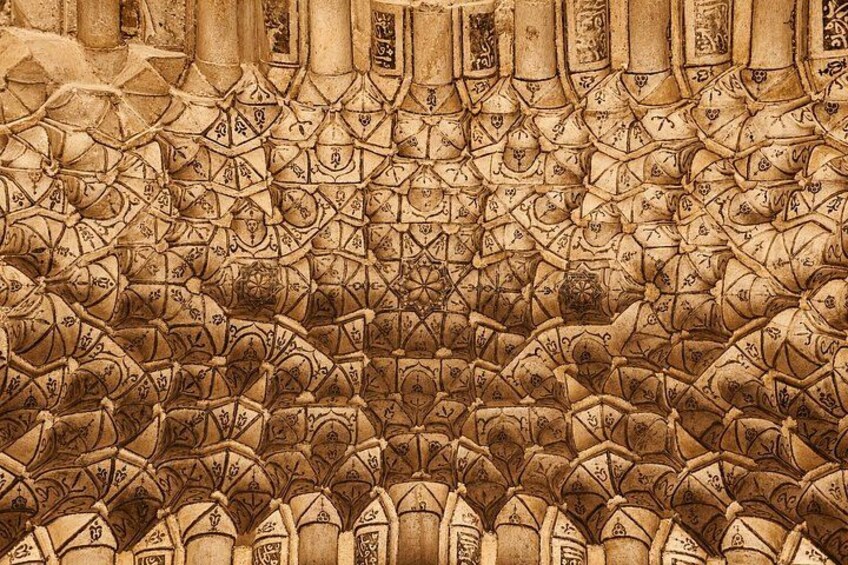 A detailed stone wall with intricate geometric patterns and symbols. 4
