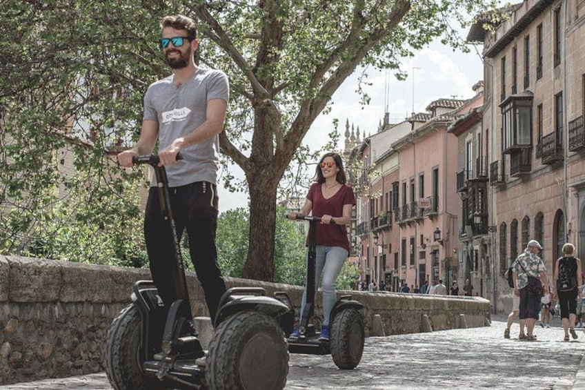 Une personne circule à bord d’un Segway sur une rue pavée, avec des bâtiments historiques en arrière-plan. 4