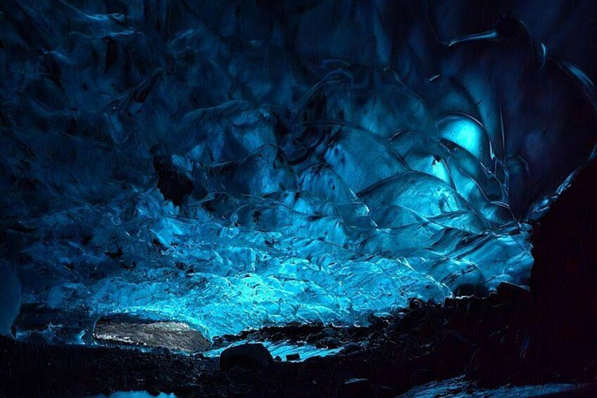 An ice cave with blue lighting and ice formations. 1