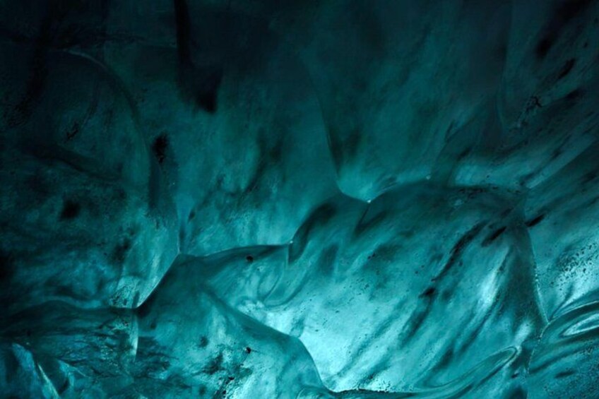 A close-up of a textured surface with a blue-green hue, possibly ice or stone. 4