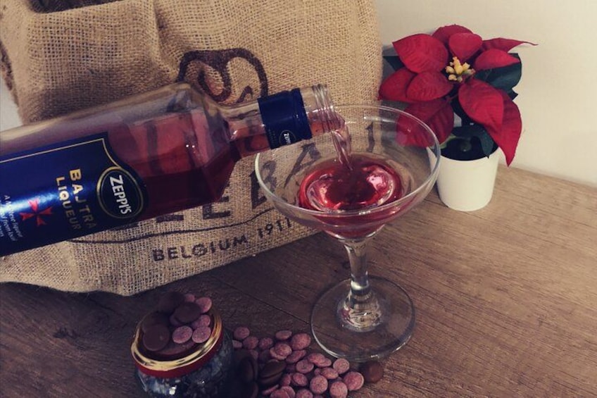 A bottle of Zepirys liqueur being poured into a martini glass. 1