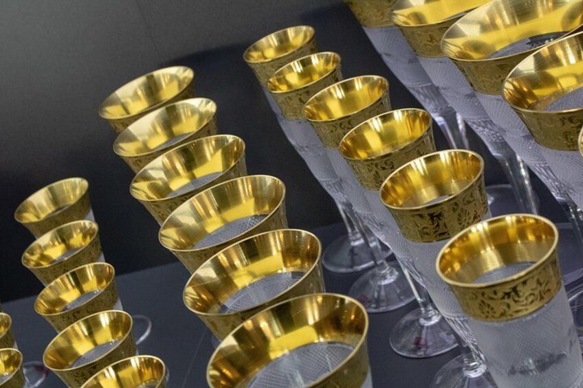 Une collection de coupes et de verres dorés disposés sur une surface. 3