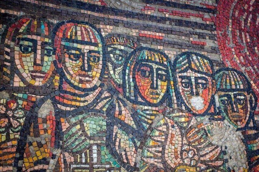 A mosaic with multiple faces, each with distinct features and expressions. 1