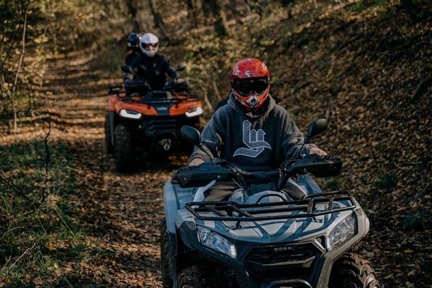 Two riders on ATVs on a forest trail. 4