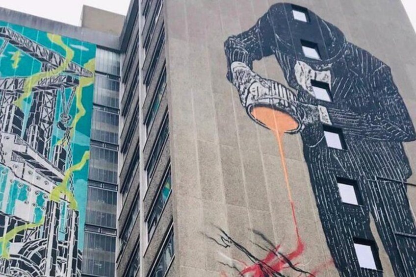 A mural of a person pouring liquid on a building. 2