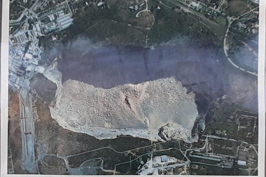 An aerial view of a coastal area with a large body of water, a sandy beach, and surrounding buildings. 2