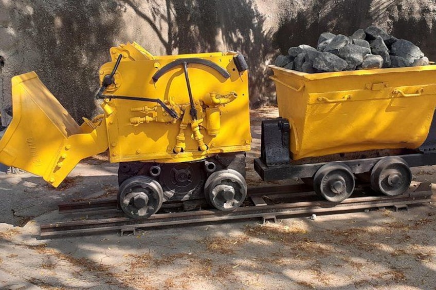 A yellow train with a hopper car filled with coal. 2