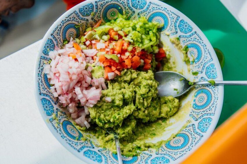 En skål guacamol med hakkede tomater og løg. 3
