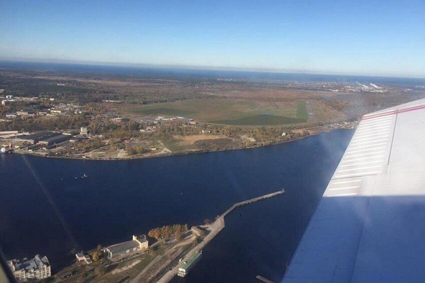 An aerial view of a coastal area with a large body of water, a small peninsula, and a runway. 2