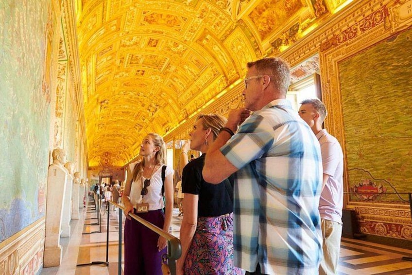 A museum interior with a golden ceiling, marble columns, and classical statues. 5