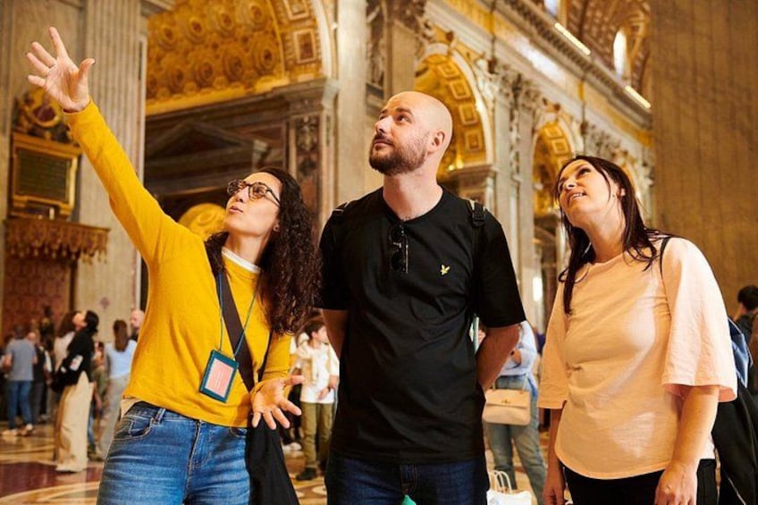 A group of people taking a selfie in a grand, ornate building with high ceilings and detailed architecture. 4