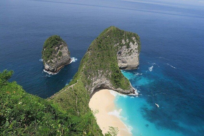 A coastal landscape with a prominent rock formation and a sandy beach. 2