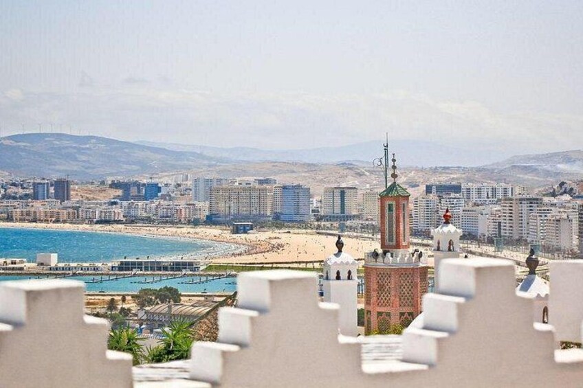 Un paisaje urbano costero con playa, edificios y una torre. 3